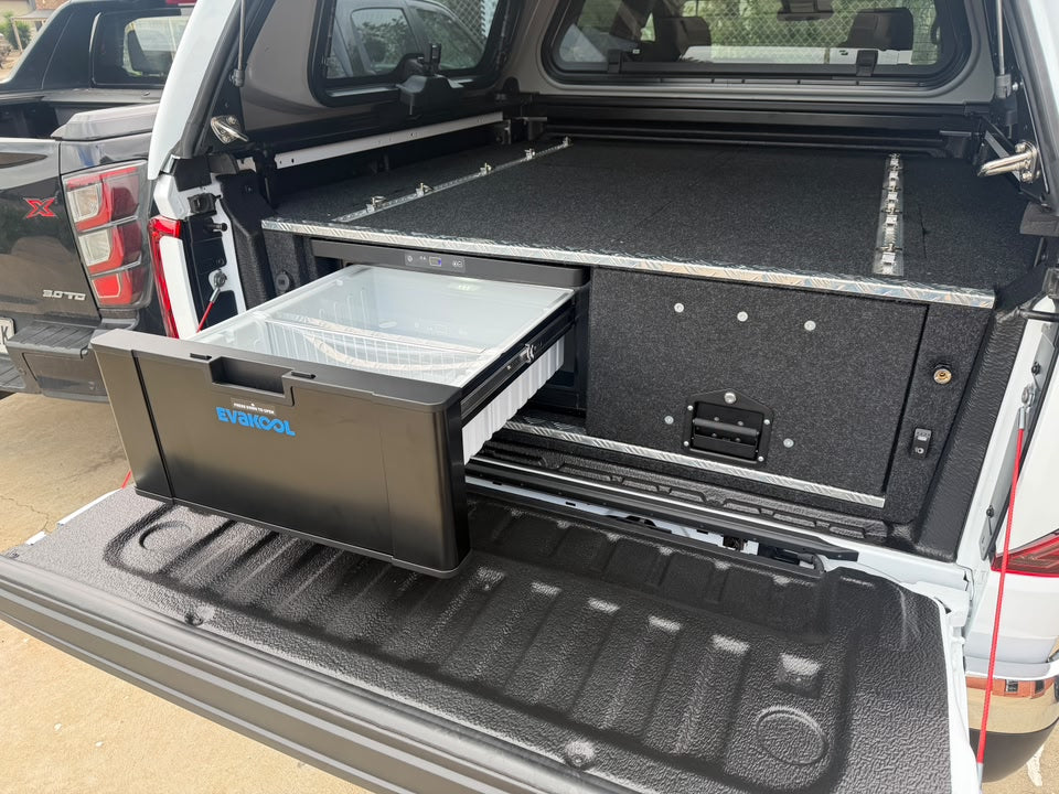 EvaKool drawer fridge extended beside a carpeted storage drawer beneath a flat ute canopy deck with tie-down tracks