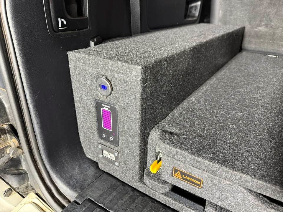 REDARC display and Anderson connection integrated into a carpeted INFINITY side wing beside a Lawson Automotive drawer