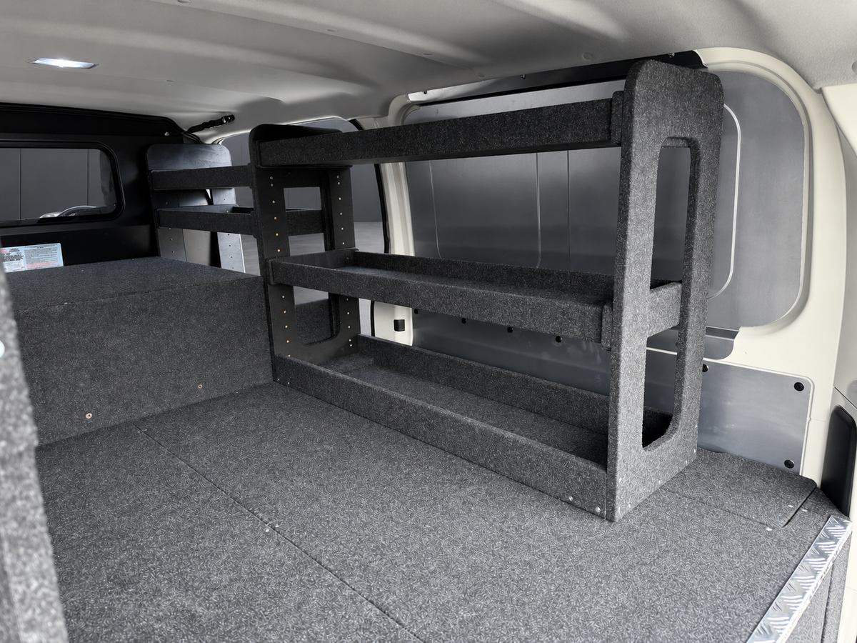 Drawer top shelving bay fitted at the rear driver's side of a van above a carpeted drawer deck