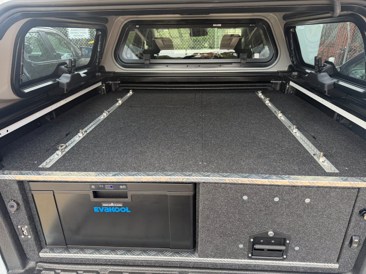 VW Amarok EvaKool 40 litre drawer fridge and storage drawer closed beneath the carpeted deck and tie-down rails