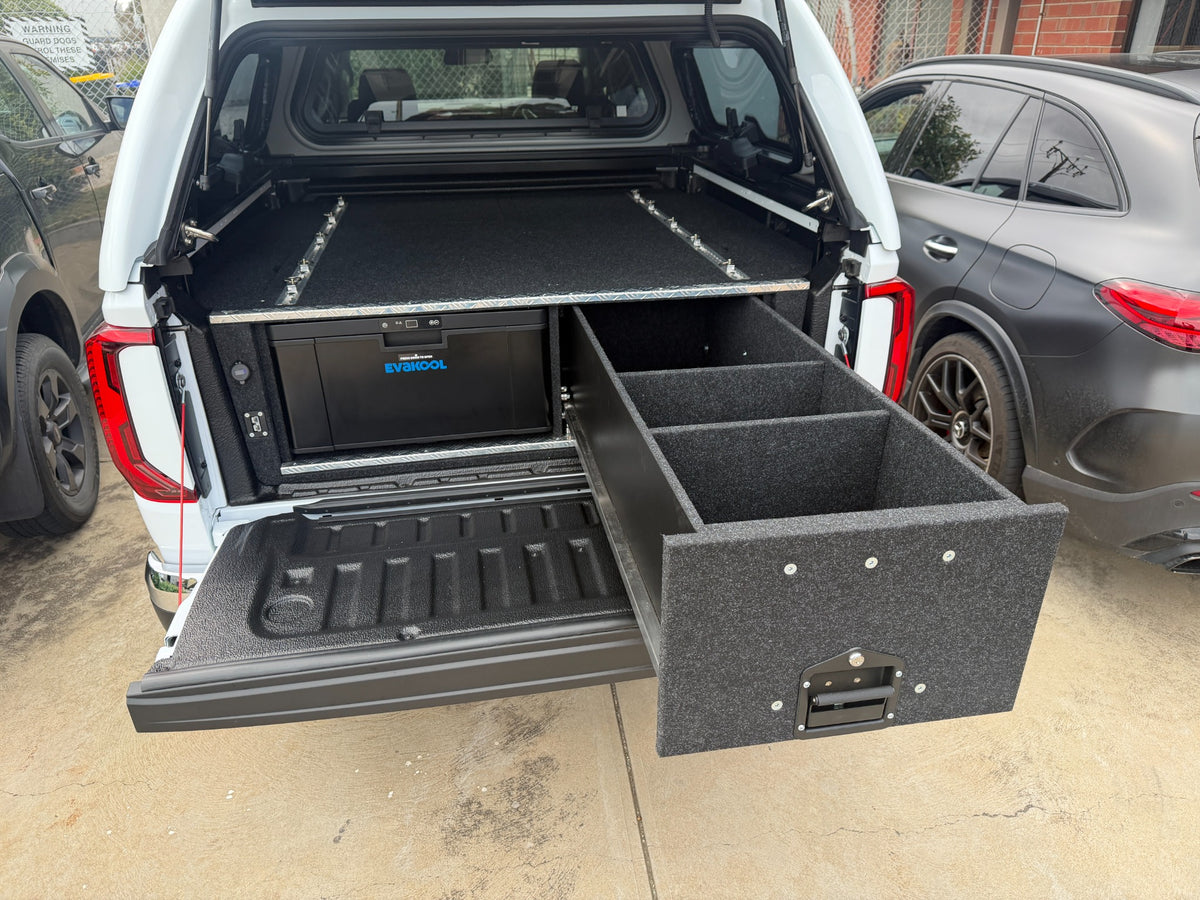 Divided Lawson storage drawer extended beside the closed EvaKool 40 litre drawer fridge in a VW Amarok