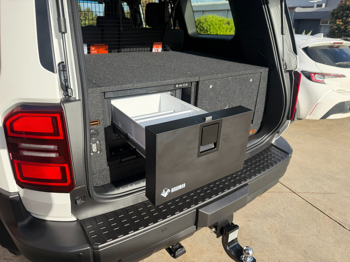 Bushman 30-litre drawer fridge open beside the Prado 250 INFINITY storage drawer; wagon installation example, ute layout differs